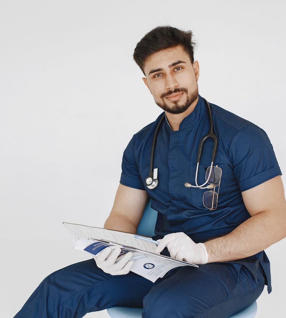 A doctor in navy scrubs reviewing medical notes