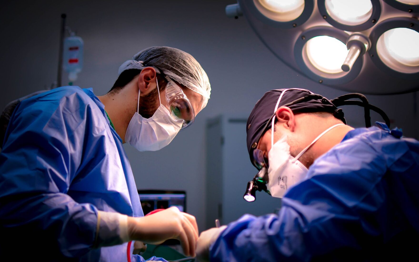 A focused surgical team performing a procedure under operating room lights